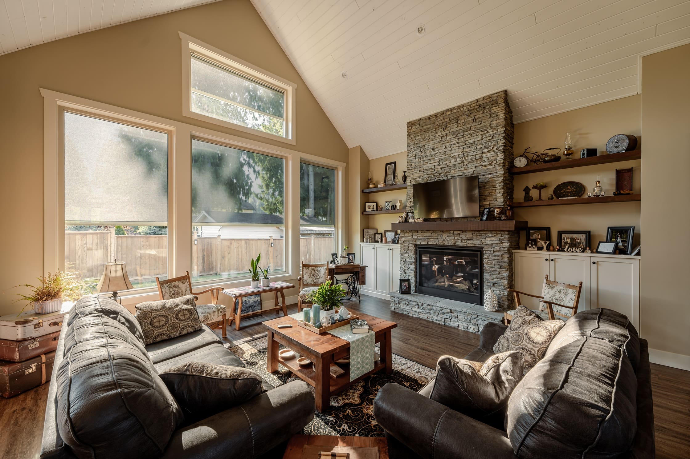 Cozy living room with motorized shades and stone fireplace